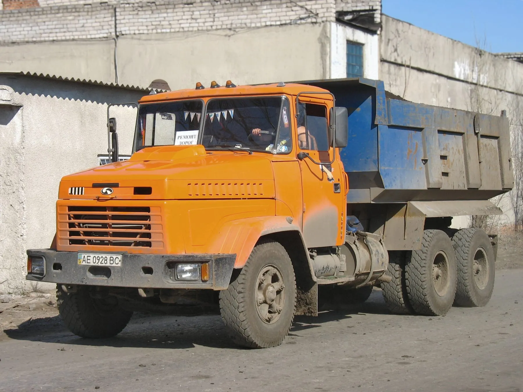 КрАЗ-6510 дорожной службы с табличкой «Ремонт дорог» за стеклом