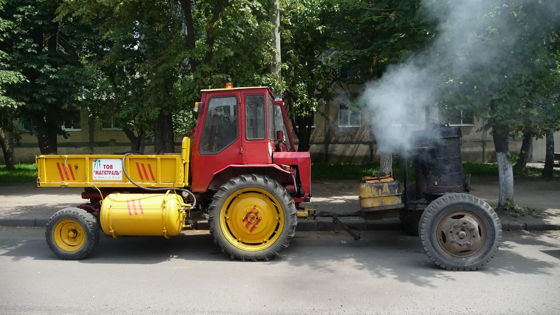 Т-16 дорожной службы буксирует котёл с горячим битумом, Украина